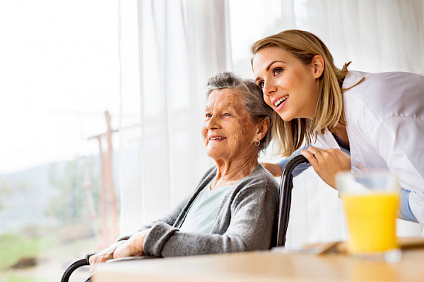 Senior Helpers caregiver providing care to elderly client in wheelchair